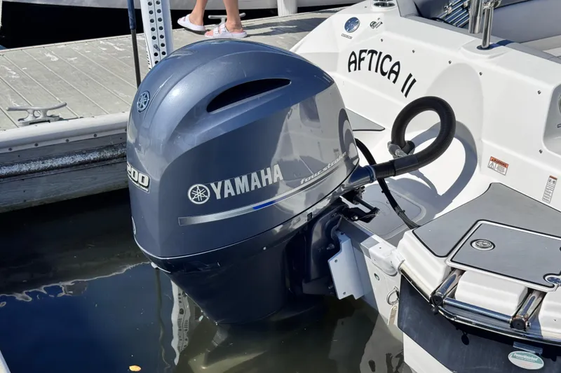Slide: The Image of 2022 NauticStar 223DC Sport Deck boat with Yamaha engine, docked outdoors. - 4