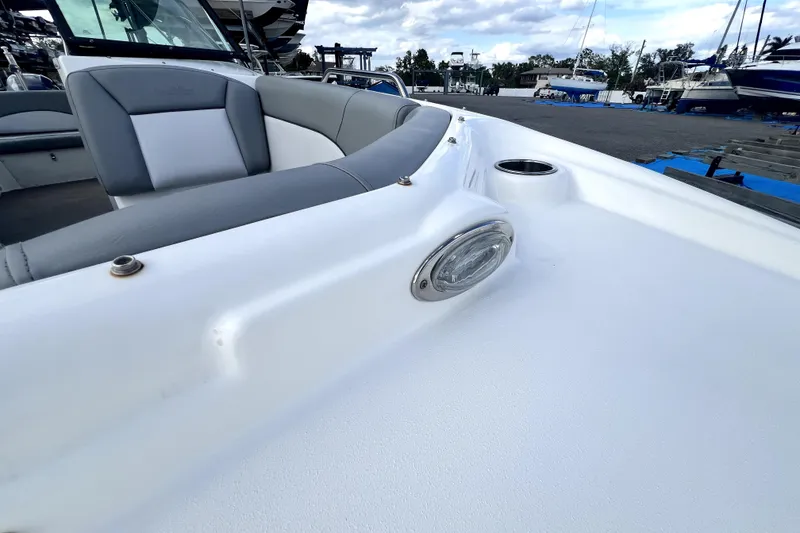 Slide: The Image of 2022 NauticStar 223DC Sport Deck boat with cushioned seating and cup holder. - 46