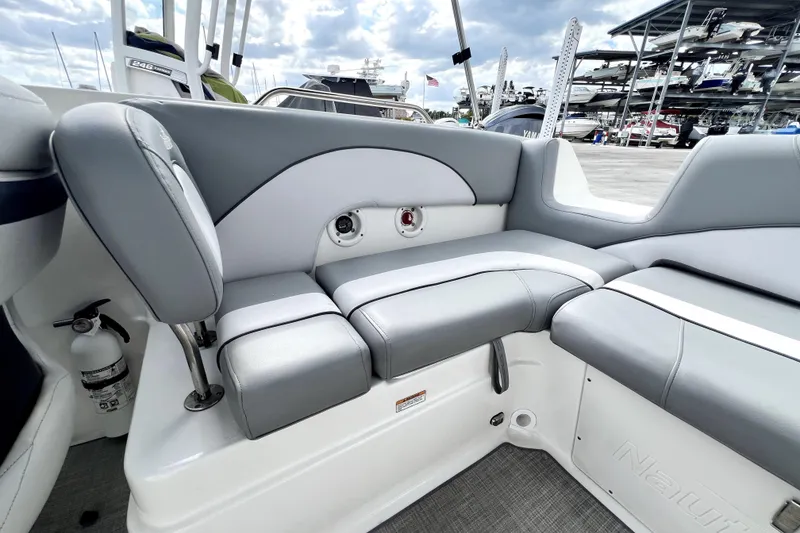 Slide: The Image of 2022 NauticStar 223DC Sport Deck boat interior with gray seating and storage compartments. - 49
