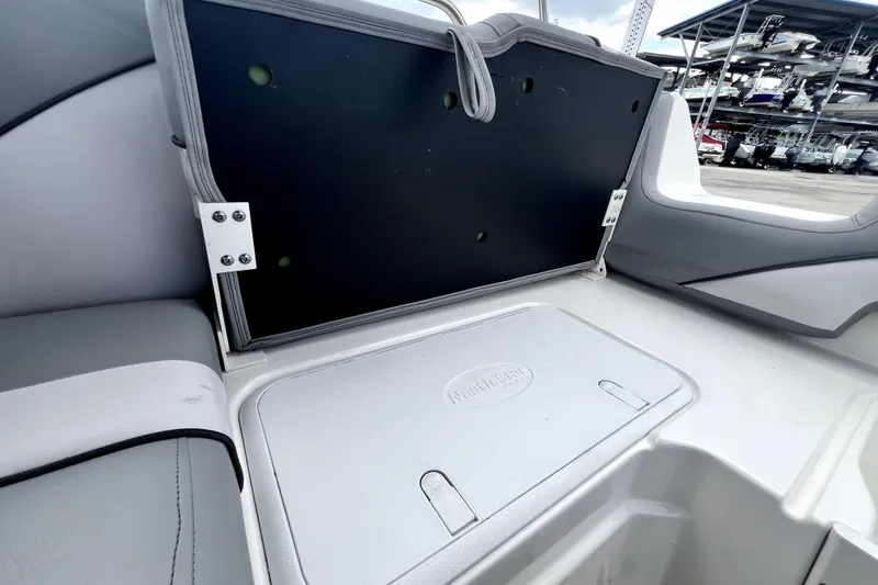 Slide: The Image of 2022 NauticStar 223DC Sport Deck boat interior with storage compartment open. - 50