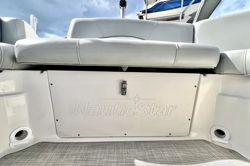 Slide: The Image of 2022 NauticStar 223DC Sport Deck boat interior with cushioned seating and storage compartment. - 52