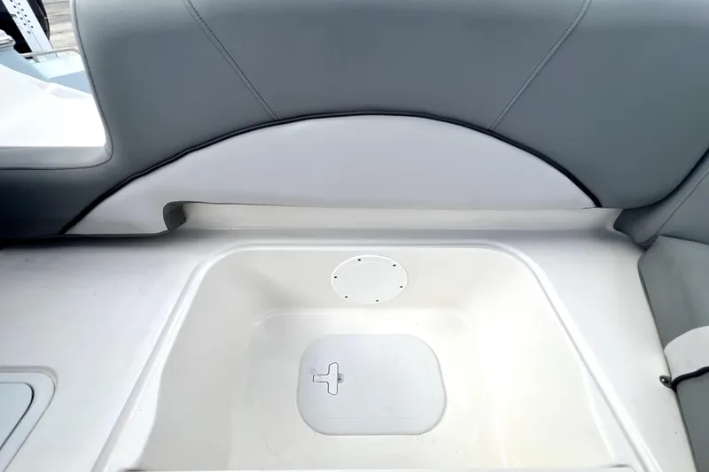 Slide: The Image of 2022 NauticStar 223DC Sport Deck boat storage compartment with gray seating. - 54