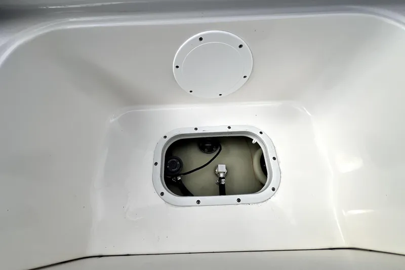 Slide: The Image of 2022 NauticStar 223DC Sport Deck boat compartment with access hatch and visible wiring. - 56