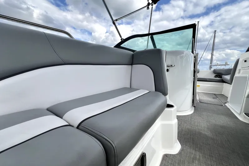 Slide: The Image of 2022 NauticStar 223DC Sport Deck interior with gray and white seating, open deck view. - 58