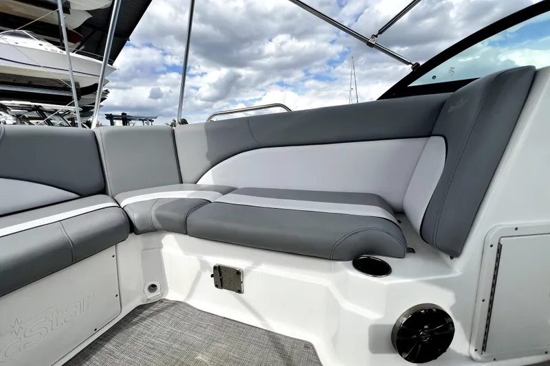 Slide: The Image of 2022 NauticStar 223DC Sport Deck interior with gray and white seating under cloudy sky. - 59