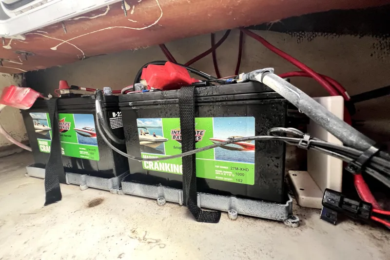 Slide: The Image of Marine batteries in a 2022 NauticStar 223DC Sport Deck boat, secured with straps. - 60