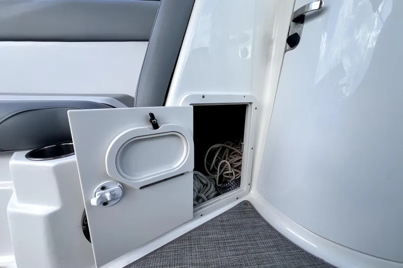 Slide: The Image of Open storage compartment on 2022 NauticStar 223DC Sport Deck boat with rope inside. - 62