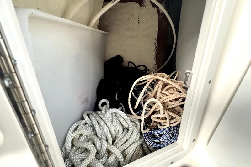 Slide: The Image of Storage compartment with ropes on a 2022 NauticStar 223DC Sport Deck boat. - 63