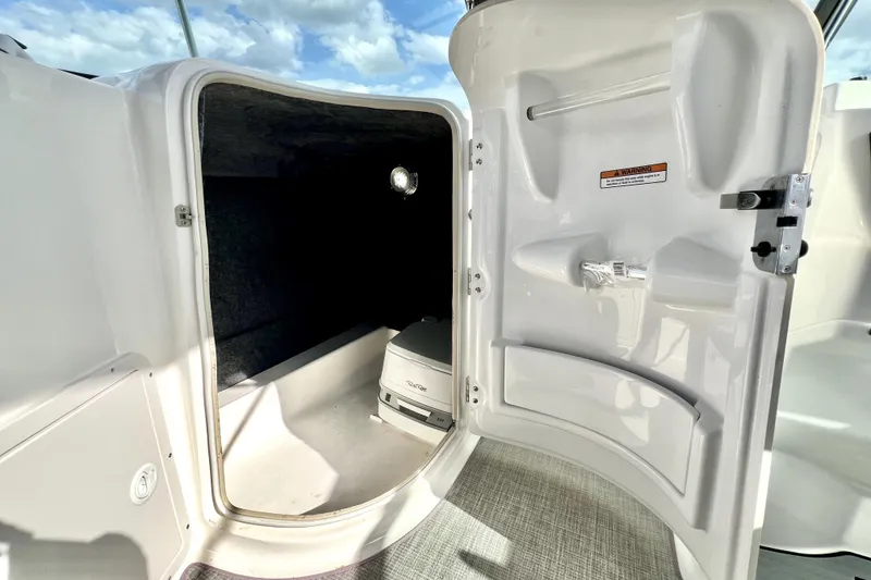 Slide: The Image of 2022 NauticStar 223DC Sport Deck interior cabin with portable toilet and storage. - 66