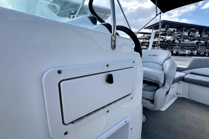 Slide: The Image of 2022 NauticStar 223DC Sport Deck interior with seating and storage compartment. - 80