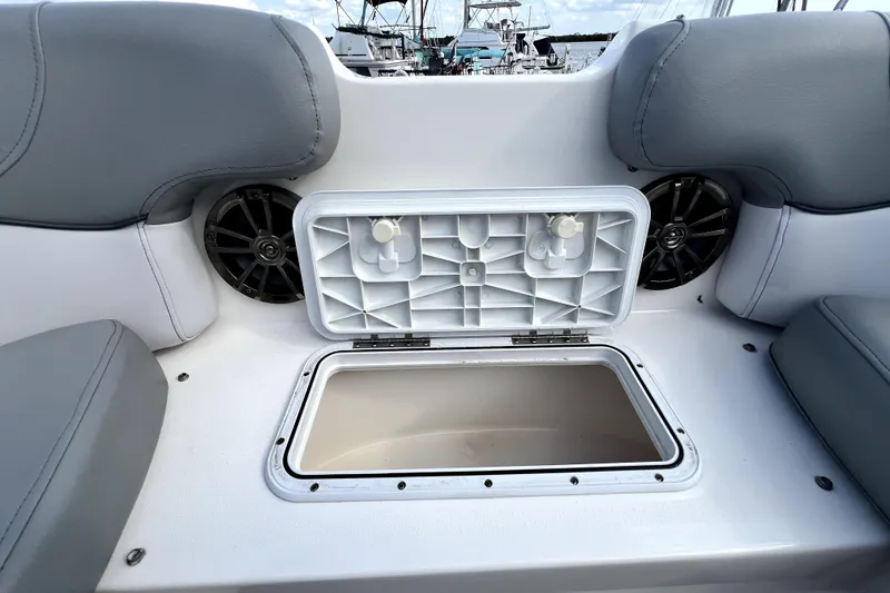 Slide: The Image of 2022 NauticStar 223DC Sport Deck boat with open storage compartment and speakers. - 87