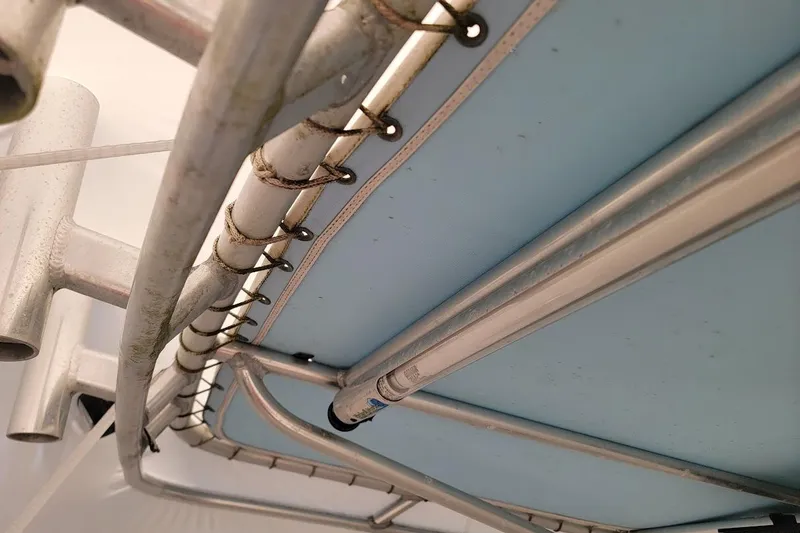 Slide: The Image of Close-up of a 2003 SeaCraft SC 23 Classic boat's metal framework and blue canopy. - 10