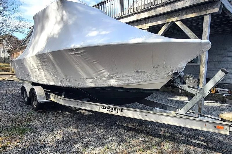 Slide: The Image of 2003 SeaCraft SC 23 Classic boat covered on a trailer in a driveway. - 12