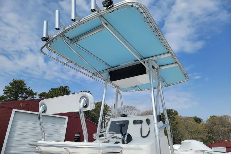 Slide: The Image of 2003 SeaCraft SC 23 Classic boat with blue T-top and rod holders against a cloudy sky. - 16