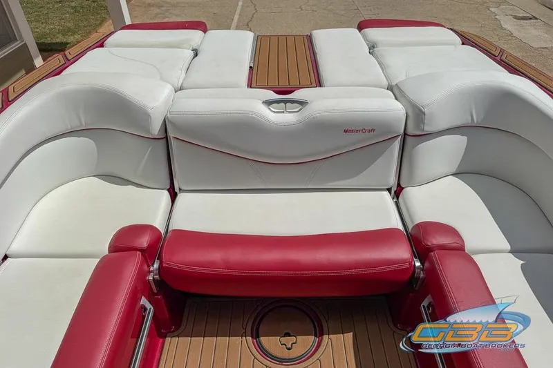 Slide: The Image of 2018 MasterCraft XT25 boat interior with red and white seating, wooden flooring. - 11