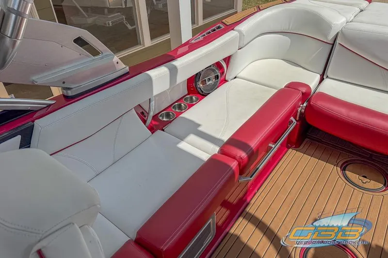 Slide: The Image of 2018 MasterCraft XT25 boat interior with red and white seating, cup holders, and teak flooring. - 12