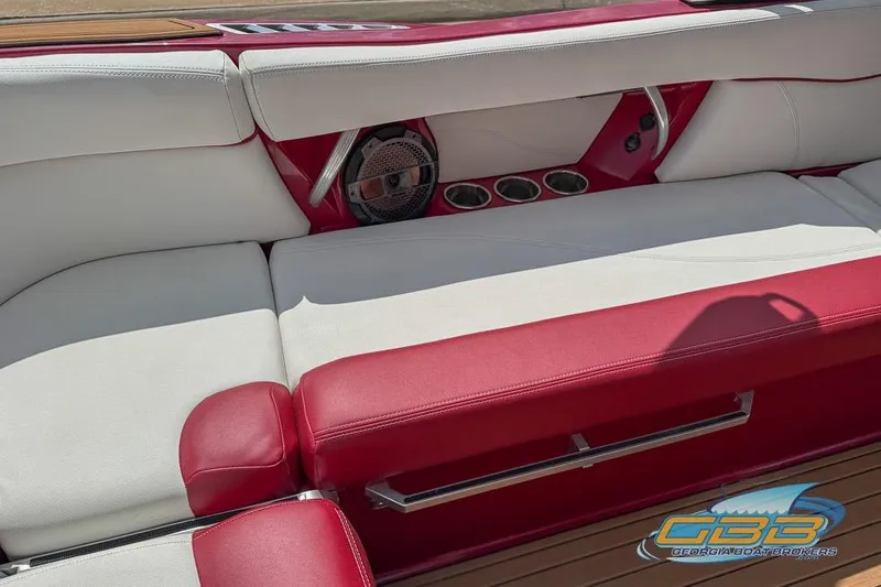 Slide: The Image of Red and white interior of 2018 MasterCraft XT25 boat with cup holders and speaker. - 14