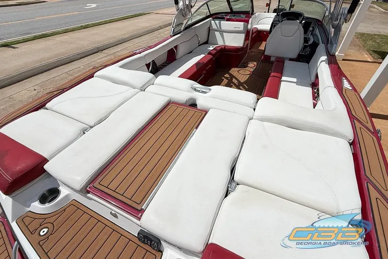 Slide: The Image of 2018 MasterCraft XT25 boat interior with white and red seating, wooden accents, and spacious layout. - 15