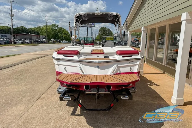 Slide: The Image of 2018 MasterCraft XT25 boat with red and white design, parked outdoors. - 17