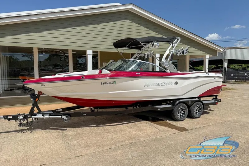 Slide: The Image of 2018 MasterCraft XT25 boat on trailer, displayed outside a dealership. - 19