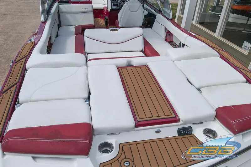 Slide: The Image of 2018 MasterCraft XT25 boat interior with white and red seating, wooden accents. - 20