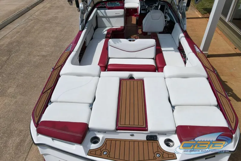 Slide: The Image of 2018 MasterCraft XT25 boat interior with white and red seating, wooden accents. - 22