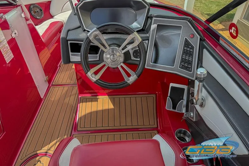 Slide: The Image of 2018 MasterCraft XT25 boat on trailer, red and white, parked outside a building. - 3