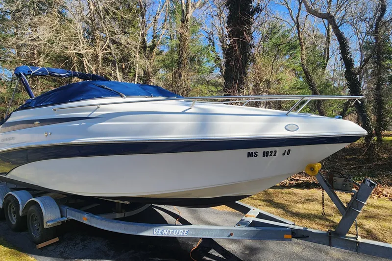 The Image of 2006 Crownline 236 SC boat on trailer, parked outdoors with trees in background. - 0