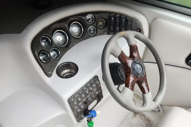 Slide: The Image of Steering wheel and dashboard of a 2006 Crownline 236 SC boat, featuring gauges and controls. - 7