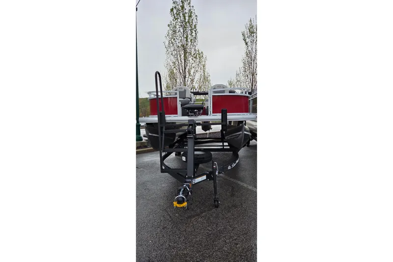 Slide: The Image of 2026 Sun Tracker Bass Buggy 16 XL Select pontoon boat on trailer in parking lot. - 4