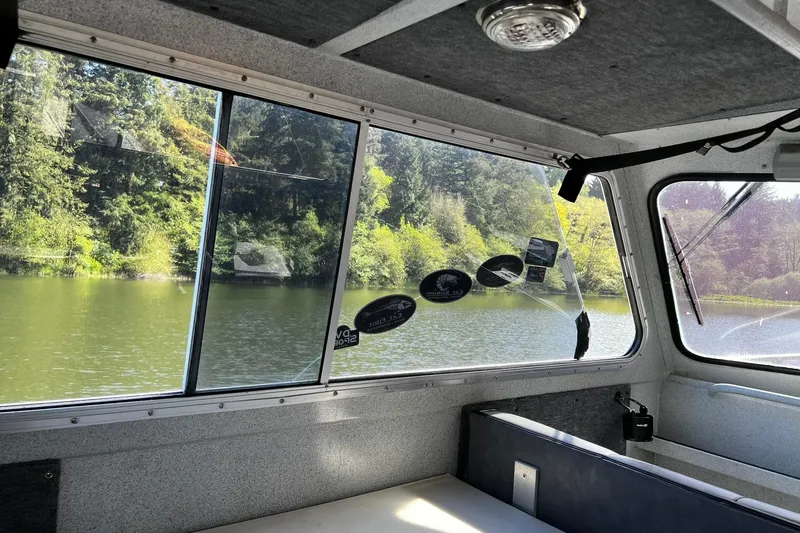 Slide: The Image of Interior view of 1998 Maxweld Cuddy Hardtop boat with scenic lake and forest outside. - 13