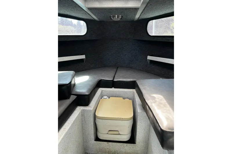 Slide: The Image of Interior of a 1998 Maxweld Cuddy Hardtop boat with cushioned seating and portable toilet. - 14