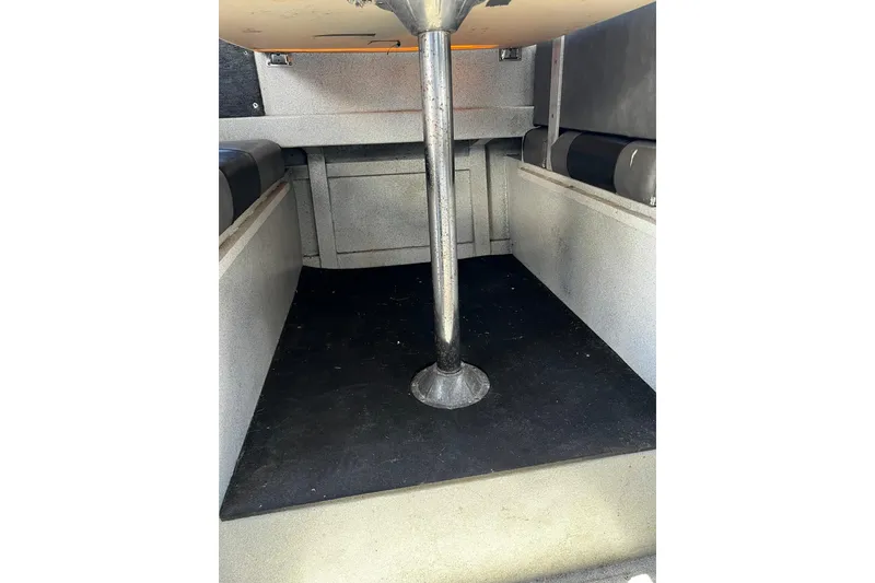 Slide: The Image of Interior view of a 1998 Maxweld Cuddy Hardtop boat, featuring seating and a central table support. - 15