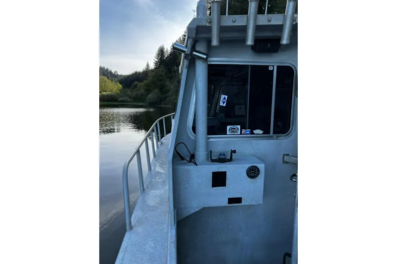 Slide: The Image of 1998 Maxweld Cuddy Hardtop boat on calm water, surrounded by lush greenery. - 21
