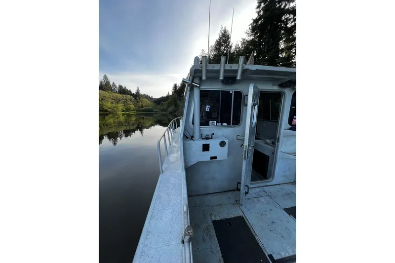 Slide: The Image of 1998 Maxweld Cuddy Hardtop boat on calm river, surrounded by lush trees. - 22