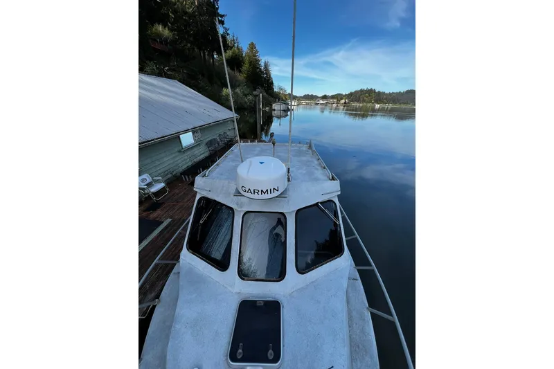 Slide: The Image of 1998 Maxweld Cuddy Hardtop boat docked on calm water with Garmin equipment. - 25