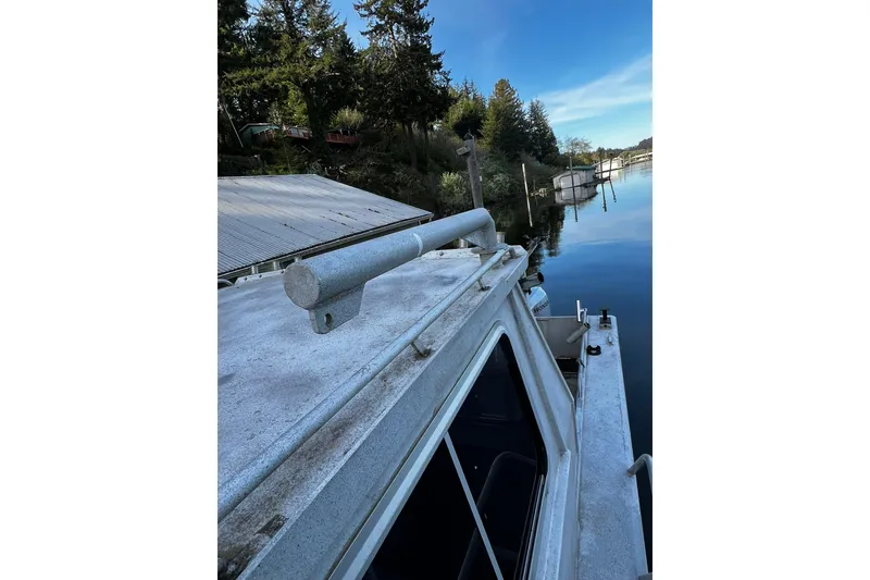 Slide: The Image of 1998 Maxweld Cuddy Hardtop boat docked by a serene lakeside with trees. - 26