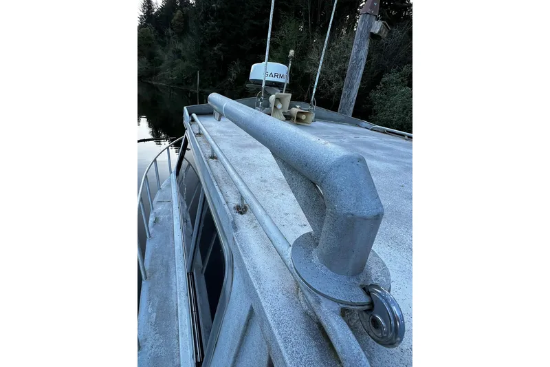 Slide: The Image of 1998 Maxweld Cuddy Hardtop boat roof with railing, docked near forested shoreline. - 27