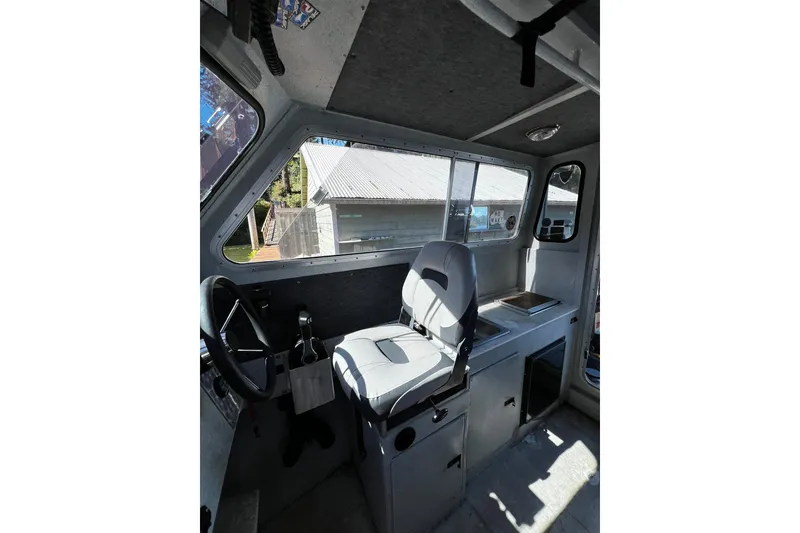 Slide: The Image of Interior of a 1998 Maxweld Cuddy Hardtop boat, featuring steering wheel and seating. - 8