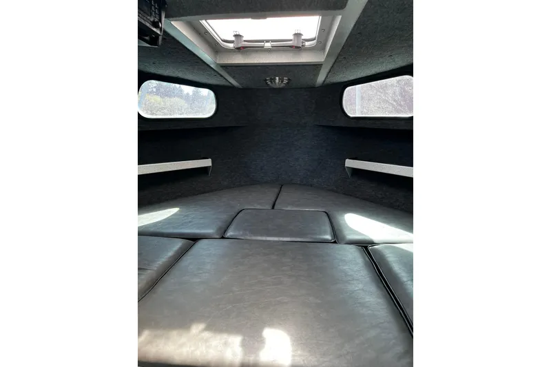 Slide: The Image of Interior of 1998 Maxweld Cuddy Hardtop boat, featuring cushioned seating and overhead hatch. - 9