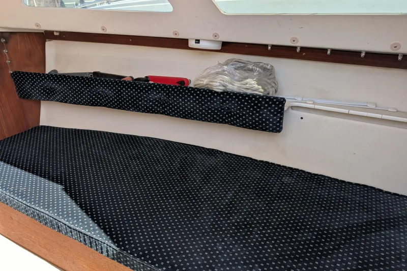 Slide: The Image of Interior of a 2007 Catalina 22 Mark II sailboat with cushioned seating and storage. - 13