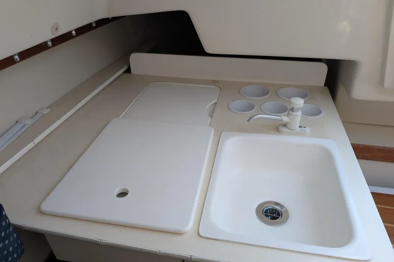 Slide: The Image of Compact galley area in a 2007 Catalina 22 Mark II sailboat, featuring a sink and storage. - 17