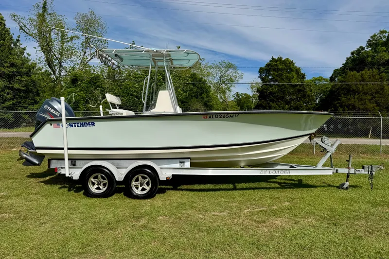 Slide: The Image of 2010 Contender 21 Open boat on trailer, featuring Yamaha outboard motor, parked on grass. - 2