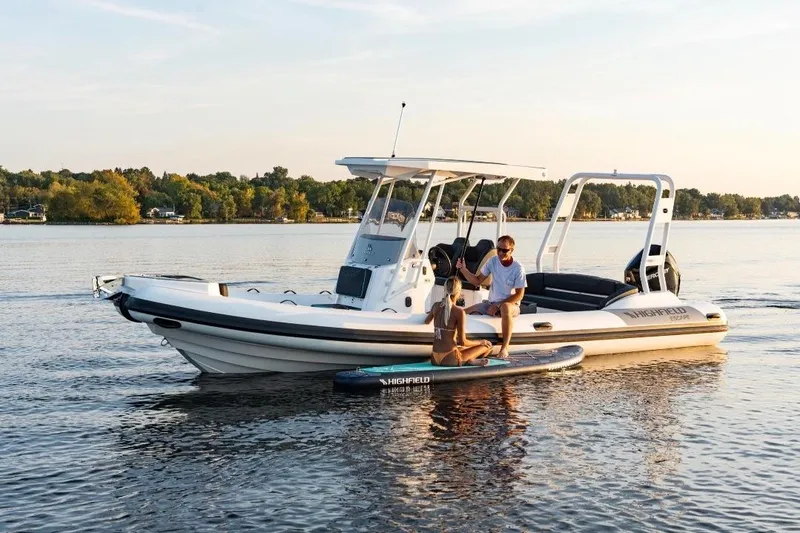 The Image of 2026 Highfield Escape 750 boat on calm lake with people enjoying water activities. - 0