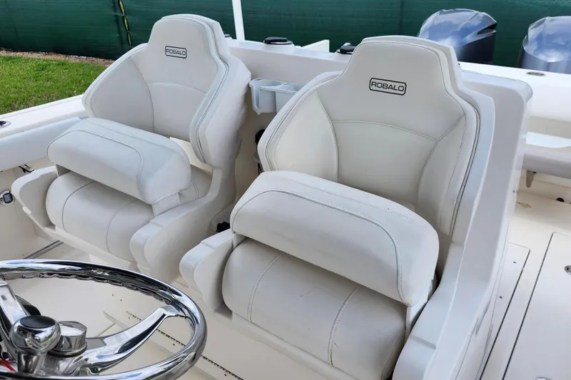 Slide: The Image of 2015 Robalo R300 Center Console boat seats with steering wheel, showcasing luxury design. - 16