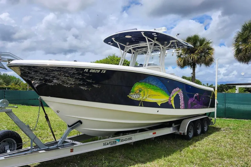 Slide: The Image of 2015 Robalo R300 Center Console boat with vibrant marine graphics on a trailer. - 2