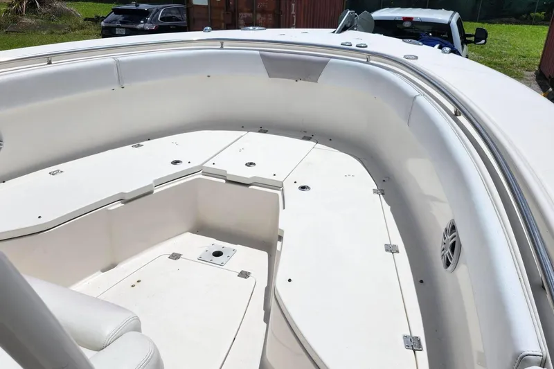 Slide: The Image of 2015 Robalo R300 Center Console boat interior with white seating and storage compartments. - 24