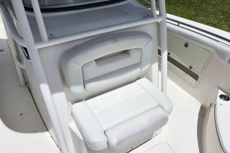 Slide: The Image of 2015 Robalo R300 Center Console boat seat, white upholstery, and storage compartment. - 26