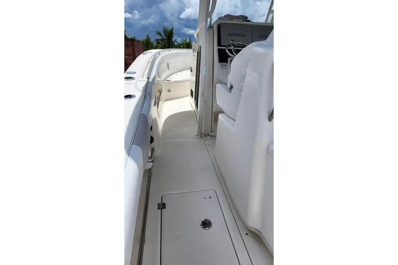 Slide: The Image of 2015 Robalo R300 Center Console boat interior with Garmin navigation, white seating, and clear skies. - 6