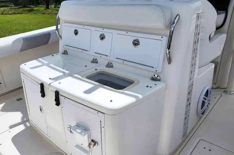 Slide: The Image of 2015 Robalo R300 Center Console boat interior with storage compartments and seating. - 8